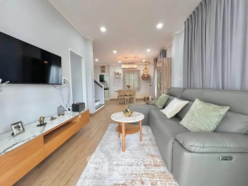 Modern living room with sleek furniture and wall-mounted TV in a stylish home.