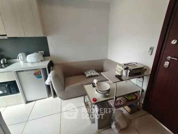 Cozy compact living area with kitchenette and modern appliances in a small apartment.