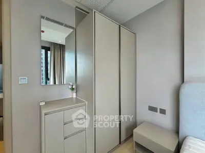 Modern bedroom with sleek wardrobe and minimalist decor in a stylish apartment.