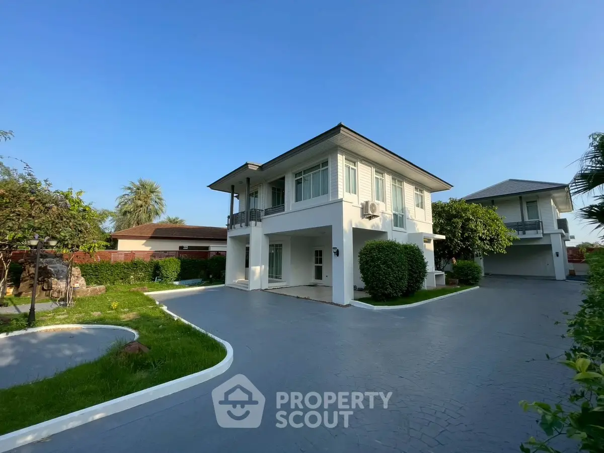 Stunning modern two-story house with spacious driveway and lush greenery, perfect for family living.