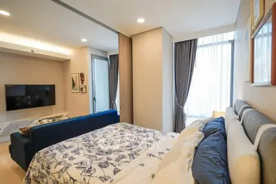 Modern bedroom with stylish decor and natural light, featuring a cozy bed and elegant curtains.