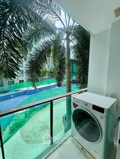 Modern condo balcony with pool view and washing machine, perfect for urban living.