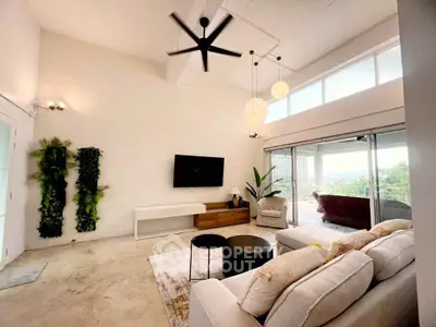 Spacious modern living room with high ceilings and large windows offering scenic views.