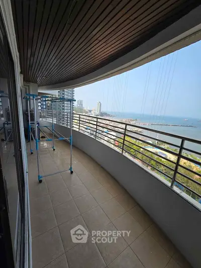 Spacious balcony with stunning ocean view in modern high-rise apartment.