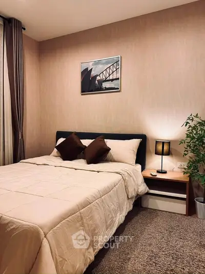 Cozy bedroom with modern decor and soft lighting, featuring a comfortable bed and stylish artwork.