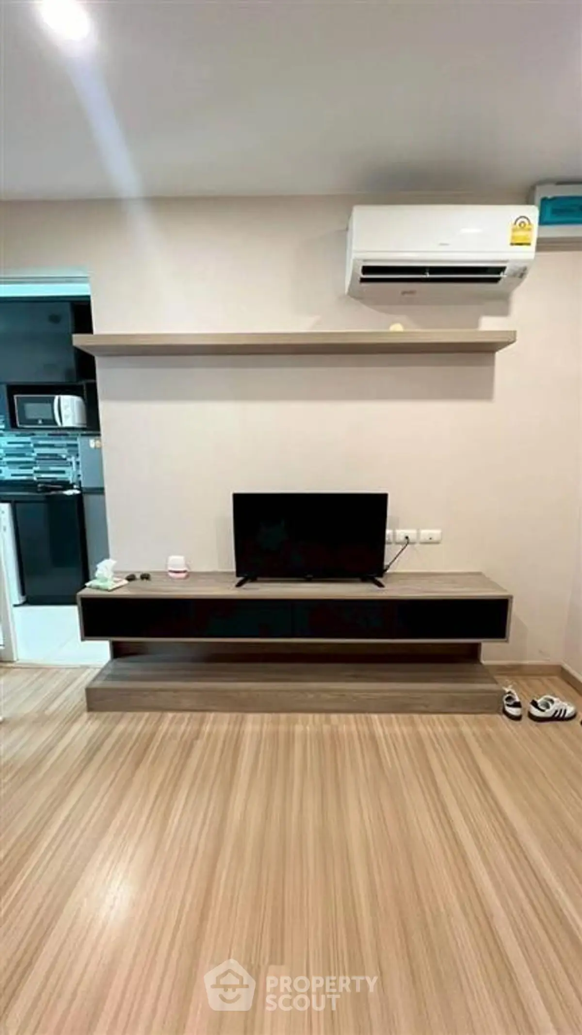 Modern living room with sleek TV stand and air conditioning unit, perfect for cozy entertainment.