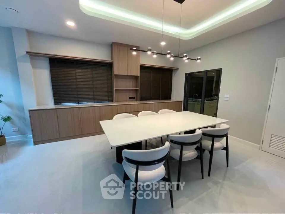 Modern dining room with sleek table, stylish chairs, and elegant lighting in a contemporary home.