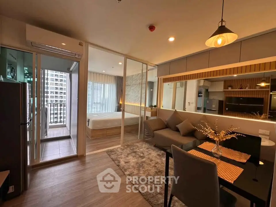 Modern open-plan living room with kitchen and bedroom, featuring stylish decor and city view balcony.