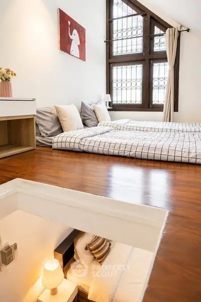 Charming loft bedroom with wooden floors and cozy decor, featuring a unique split-level design.