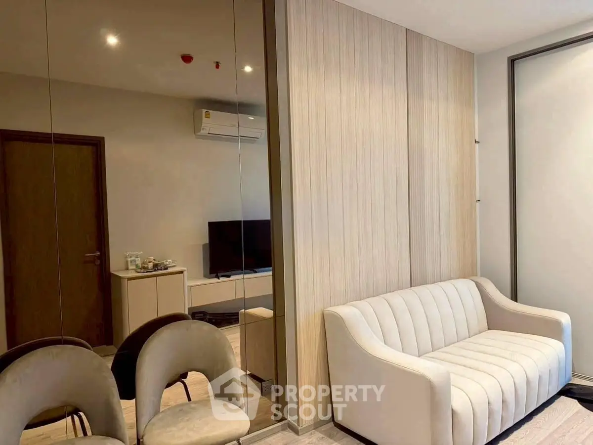 Modern living room with elegant sofa and mirrored wall in stylish apartment.