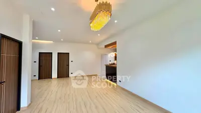 Spacious modern living room with elegant chandelier and wooden flooring