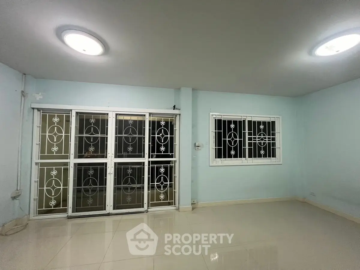 Spacious living room with modern lighting and large windows for natural light.