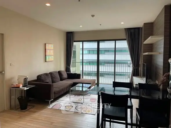 Modern living room with large windows and stylish furniture in a high-rise apartment.