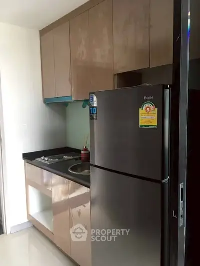 Compact modern kitchen with sleek cabinets and stainless steel fridge