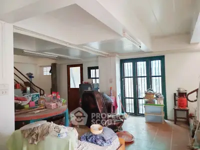 Spacious living area with potential for renovation, featuring large windows and open layout.
