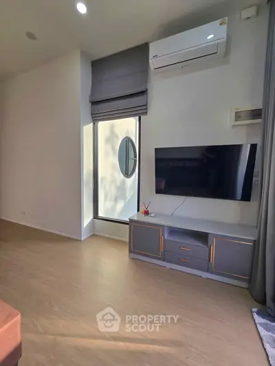 Modern living room with sleek TV setup and air conditioning