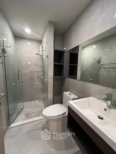 Modern bathroom with glass shower and sleek fixtures in a contemporary apartment.