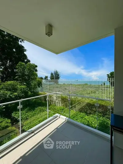 Spacious balcony with lush greenery and scenic view, perfect for relaxation and outdoor enjoyment.