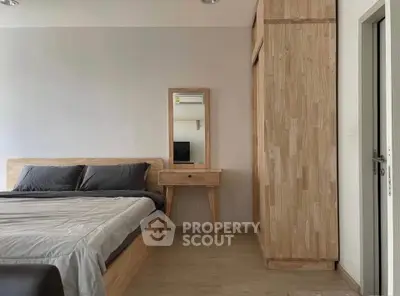 Modern bedroom with wooden furniture and sleek design, featuring a cozy bed and stylish wardrobe.