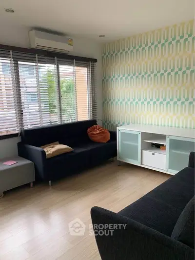 Chic living room with modern furniture and stylish wallpaper, perfect for cozy relaxation.