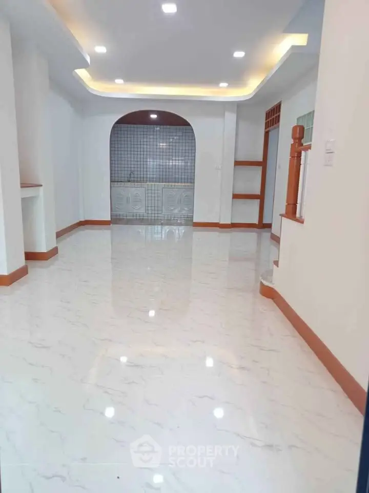 Spacious open layout living room with modern lighting and marble flooring