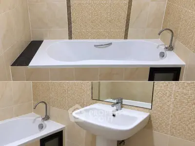 Modern bathroom with sleek bathtub and elegant sink in stylish tiled setting.