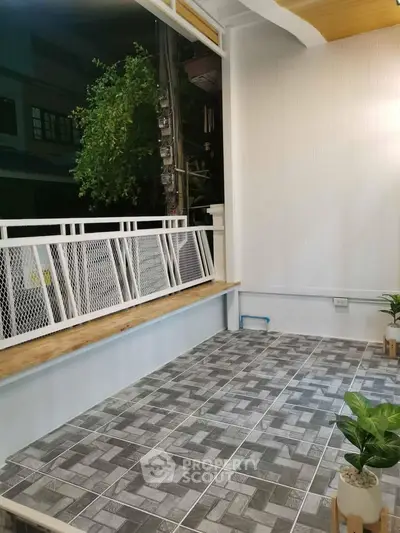Charming balcony with modern tiles and greenery, perfect for relaxation and outdoor enjoyment.