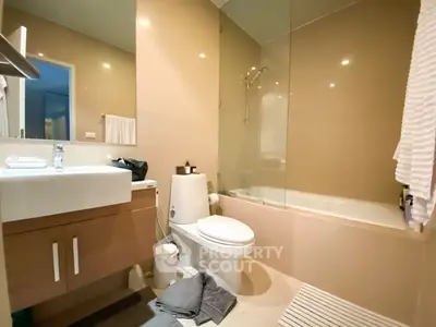 Modern bathroom with sleek fixtures and a glass-enclosed bathtub in a contemporary home.