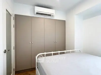 Modern bedroom with built-in wardrobe and air conditioning unit, perfect for comfortable living.