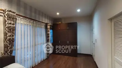 Spacious bedroom with elegant curtains and ample storage space