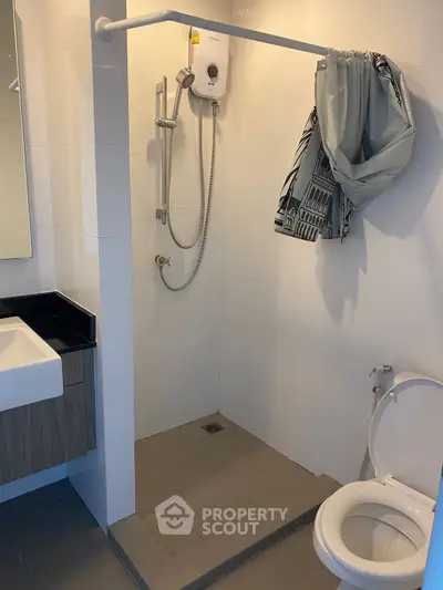Modern bathroom with shower, sink, and toilet in sleek design.