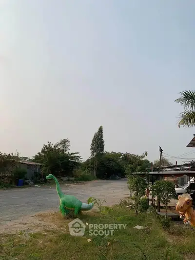 Spacious outdoor area with unique dinosaur sculptures and greenery