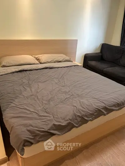 Cozy bedroom with modern bed and comfortable sofa, perfect for relaxation.