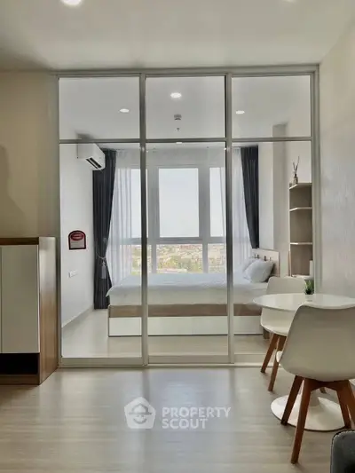 Modern apartment with glass partitioned bedroom and stylish dining area