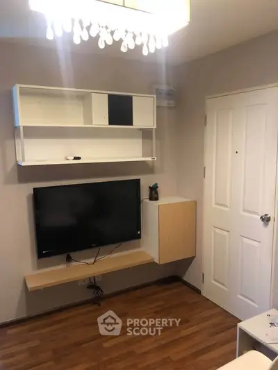 Modern living room with mounted TV and stylish shelving unit.