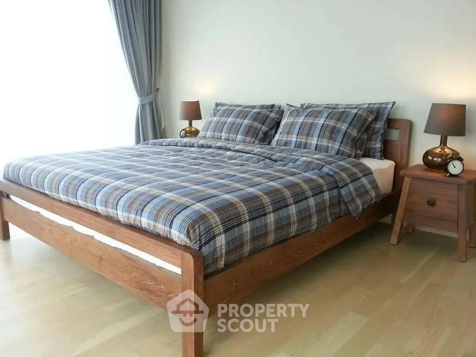 Cozy bedroom with wooden bed frame and plaid bedding, perfect for relaxation.