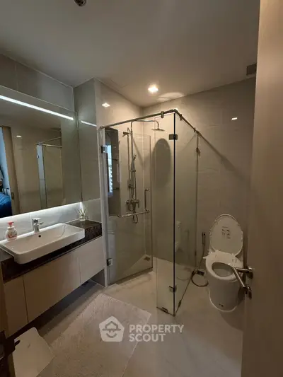 Modern bathroom with glass shower enclosure and sleek fixtures
