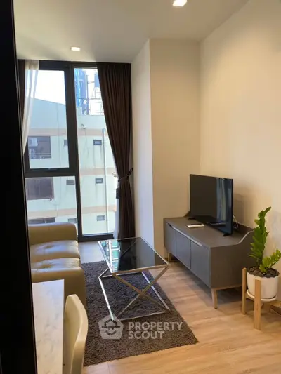 Modern living room with sleek furniture and large window in a stylish apartment.