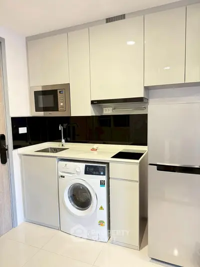 Modern compact kitchen with integrated appliances and sleek cabinetry