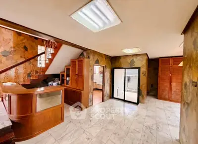 Spacious interior with wooden accents and marble flooring, ideal for a stylish home office or reception area.