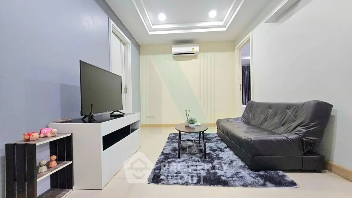 Modern living room with sleek furniture and stylish decor, featuring a cozy sofa and entertainment setup.
