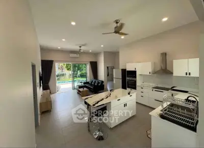 Modern open-plan kitchen and living room with sleek design and garden view.