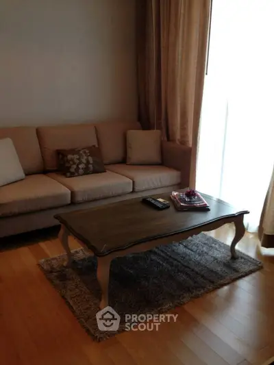 Cozy living room with elegant sofa and wooden coffee table, perfect for relaxation.