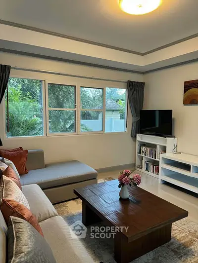Cozy living room with large windows and modern decor, perfect for relaxation.