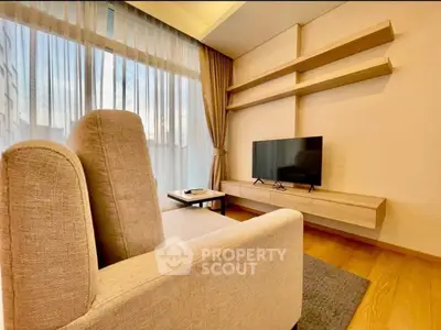 Modern living room with stylish furniture and large window offering natural light.