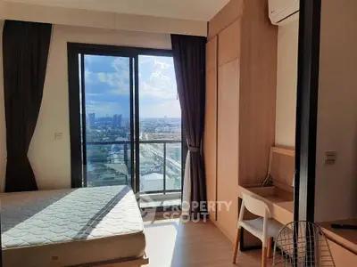 Modern bedroom with balcony offering stunning city views and ample natural light.