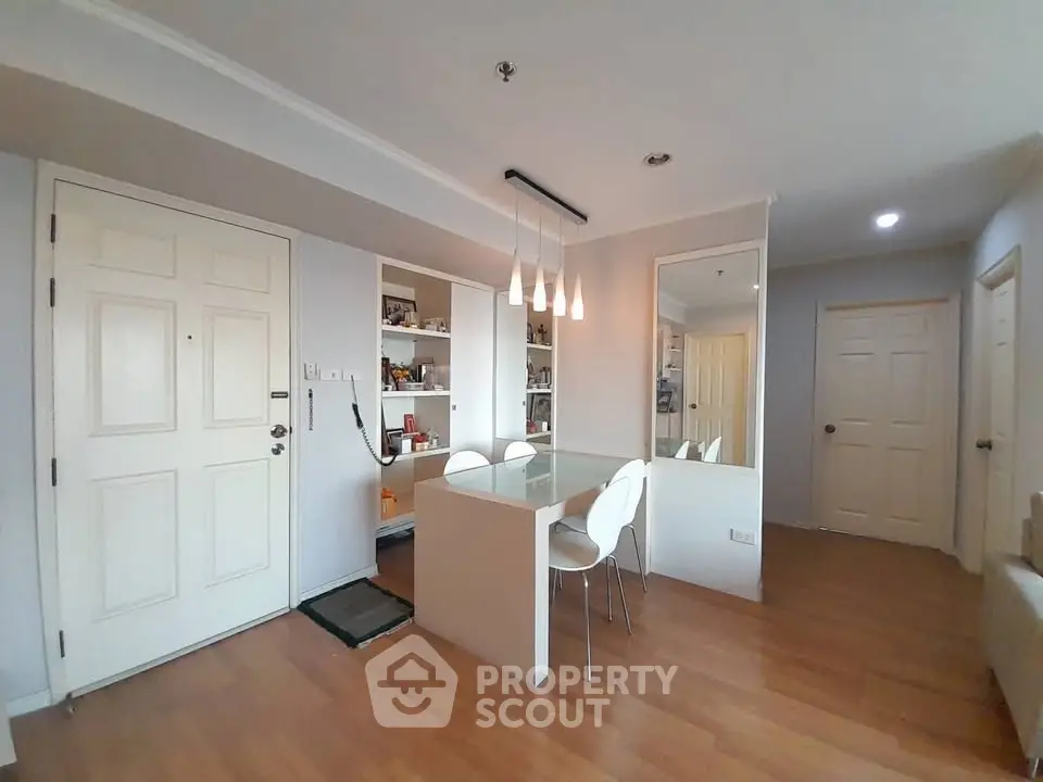 Modern dining area with sleek design and wooden flooring in a stylish apartment.