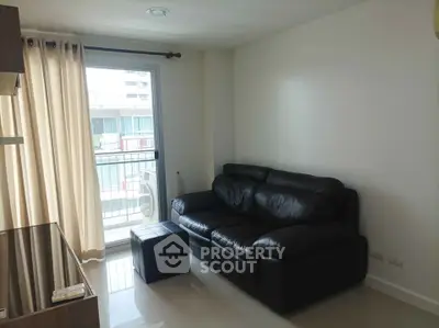 Modern living room with leather sofa and balcony view in a bright apartment.