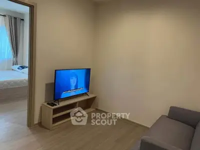 Modern living room with TV and view into cozy bedroom