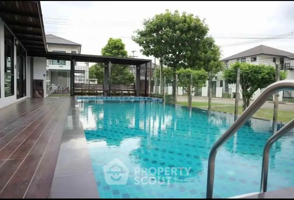 Luxurious residential pool with wooden deck and modern design in serene neighborhood.